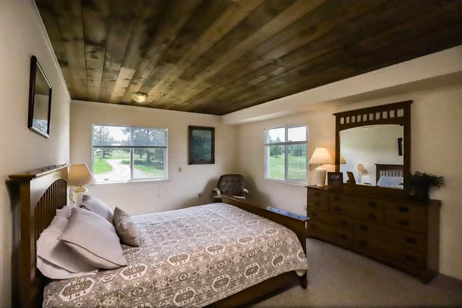 Main-floor queen bedroom with Southwestern quilt and windows on two sides