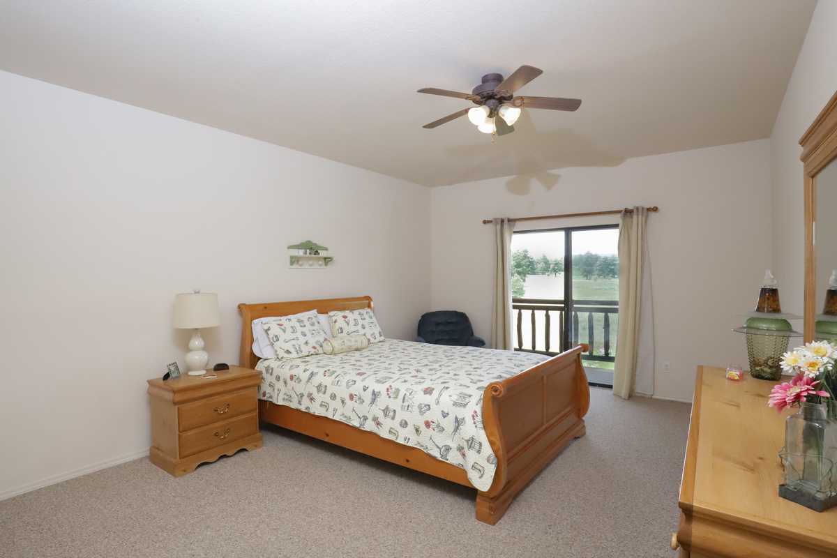 Upper-floor queen sleigh bed with a door to the balcony