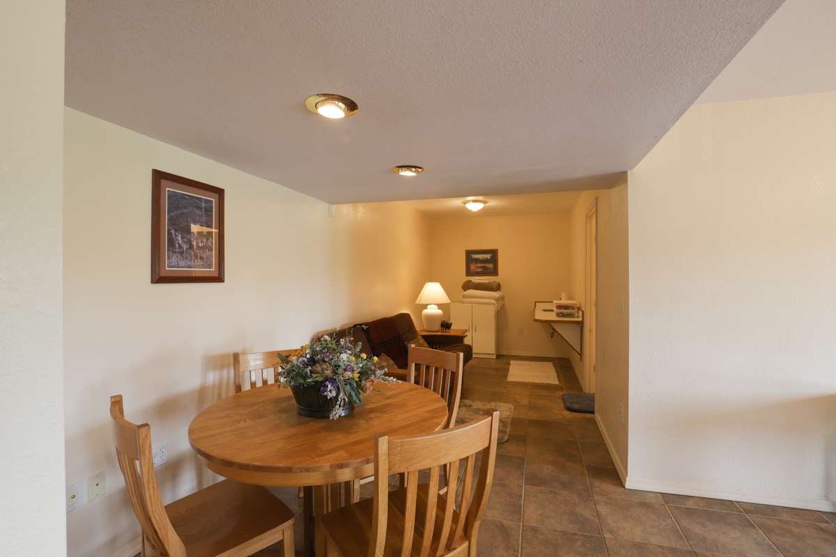 Lower-level dining nook with a round table and linen cabinet