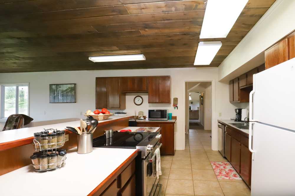 Full kitchen with range, long counters, dishwasher and refrigerator