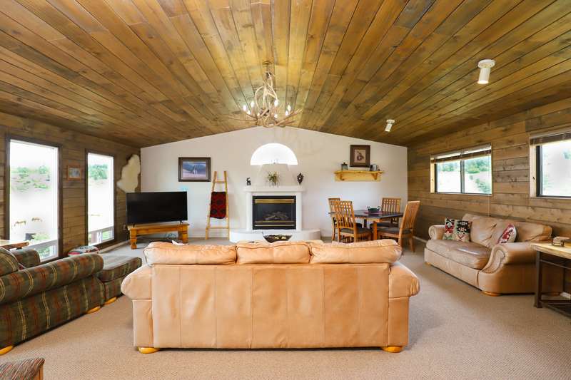 Second living room with antler chandelier, leather sofas and a game table